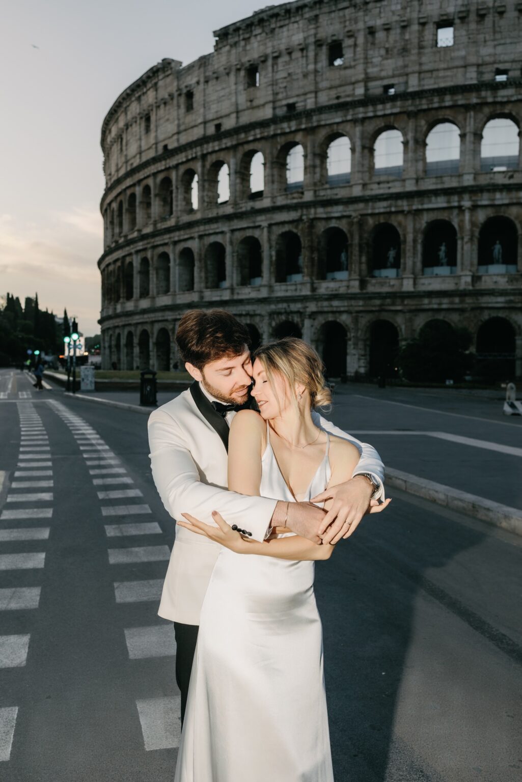 Elopement couple embracing in front of the Colosseum at sunrise