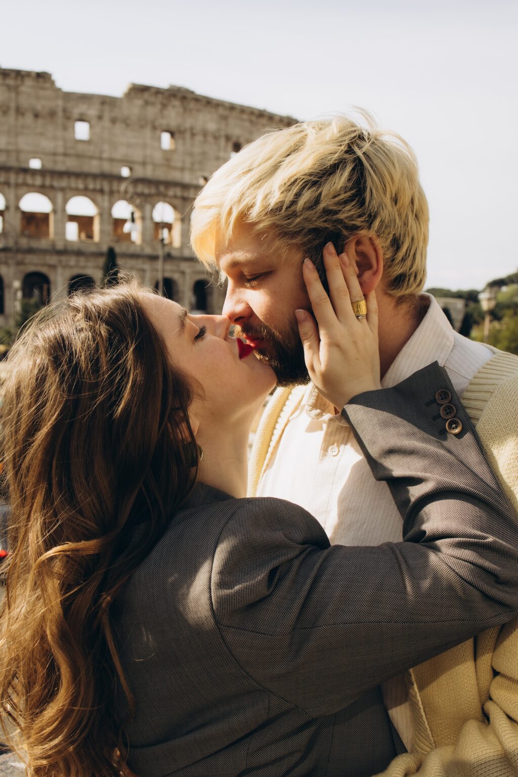 Couple kissing with the Colosseum behind
