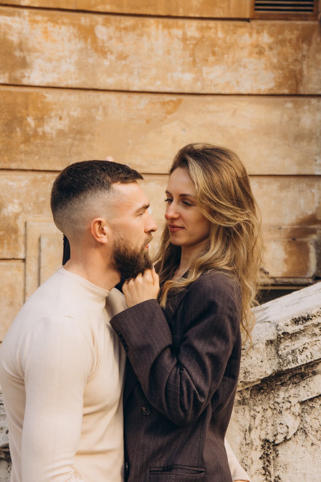 Couple against a warm ochre wall near the Spanish Steps