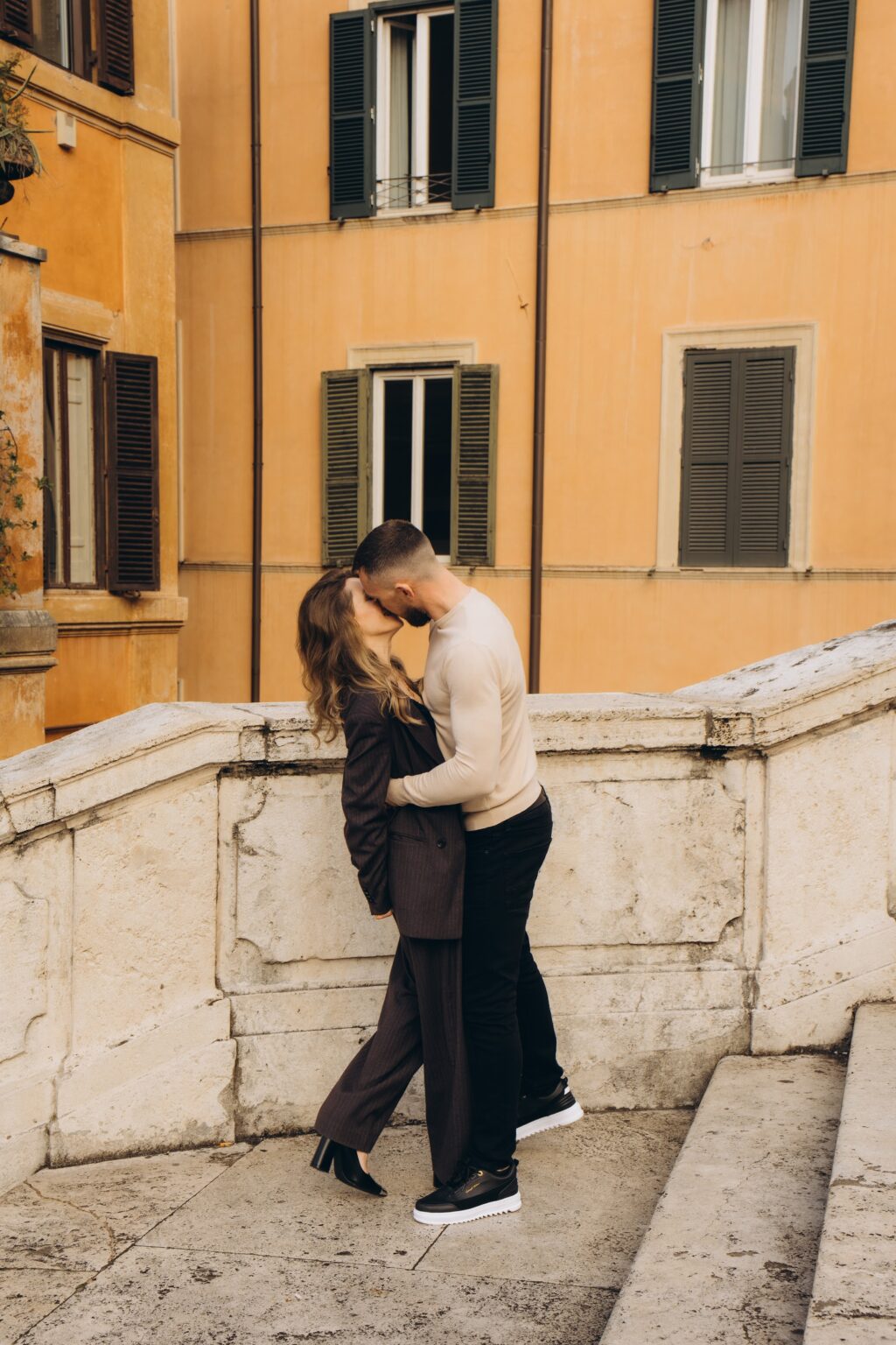 Couple on the balustrade below an orange palazzo