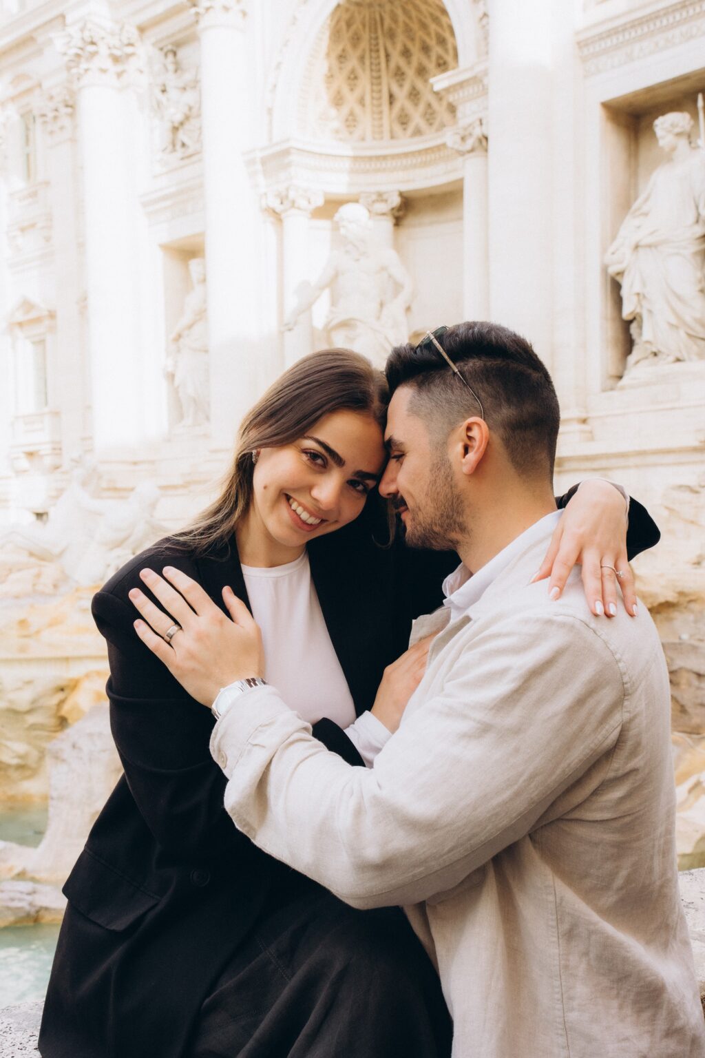 Couple embracing at the Trevi Fountain in the morning