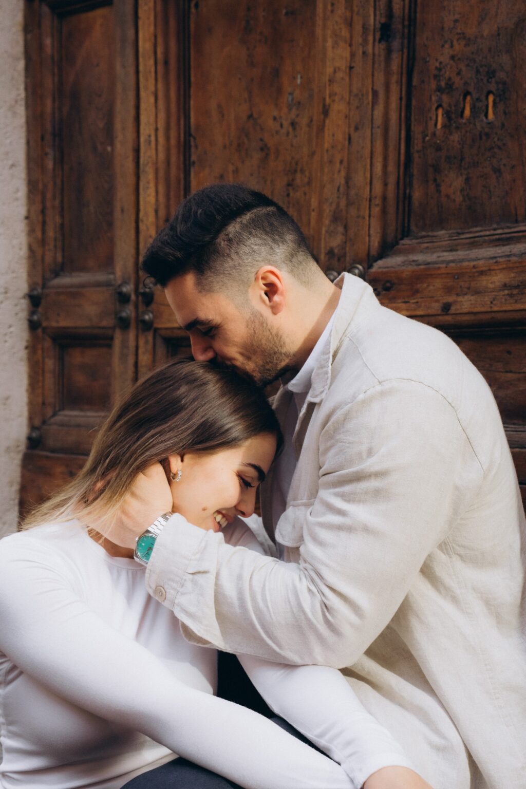 Couple sitting by an old wooden door in central Rome