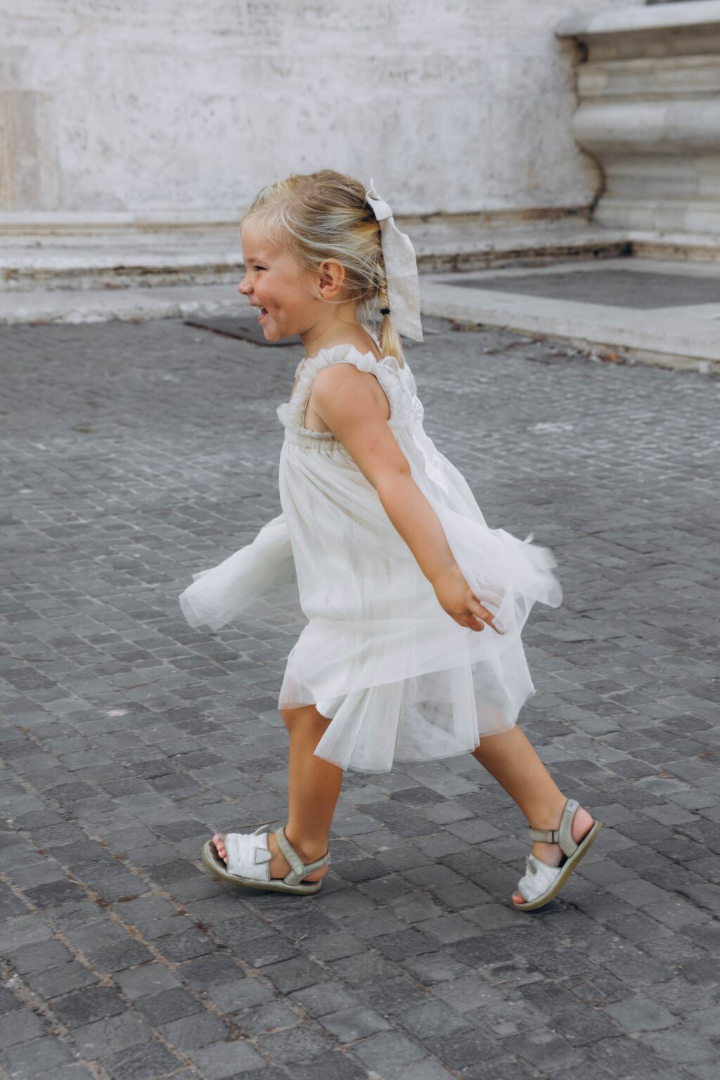 A little girl running across the Capitoline square in Rome