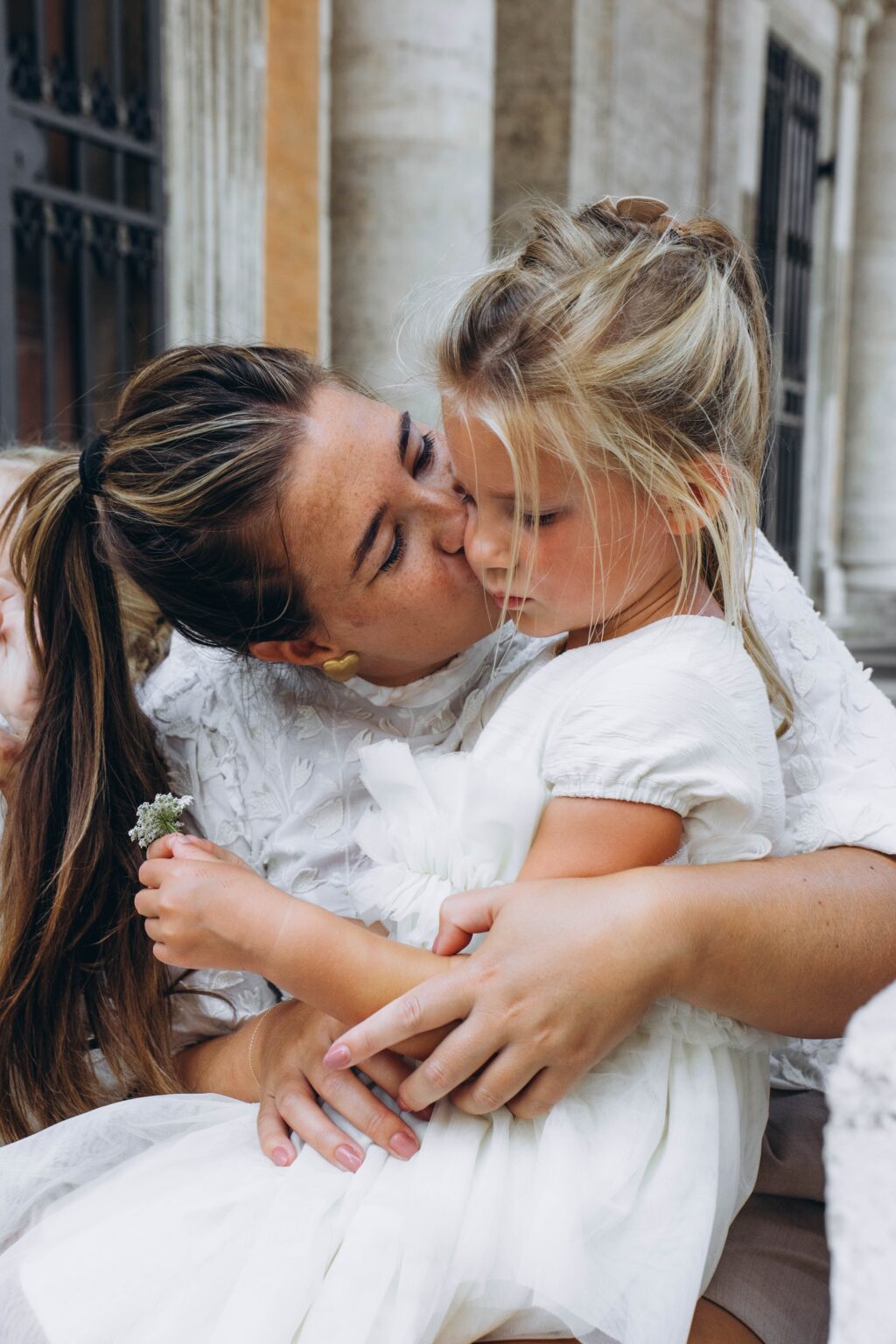 Mother kissing her daughter during a family photoshoot in Rome