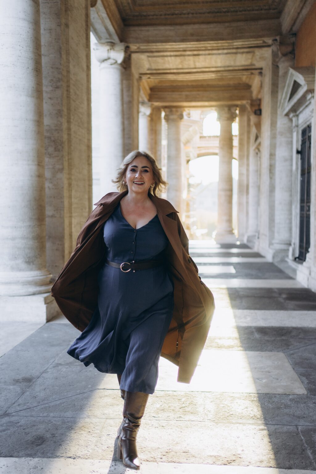 Walking through the Capitoline colonnade in a long coat