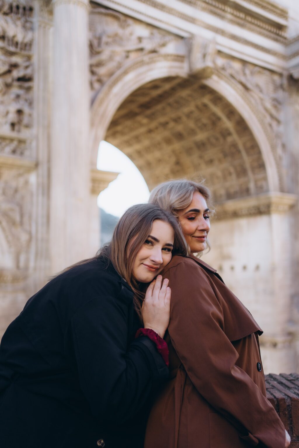 Two women embracing under the Arch of Septimius Severus
