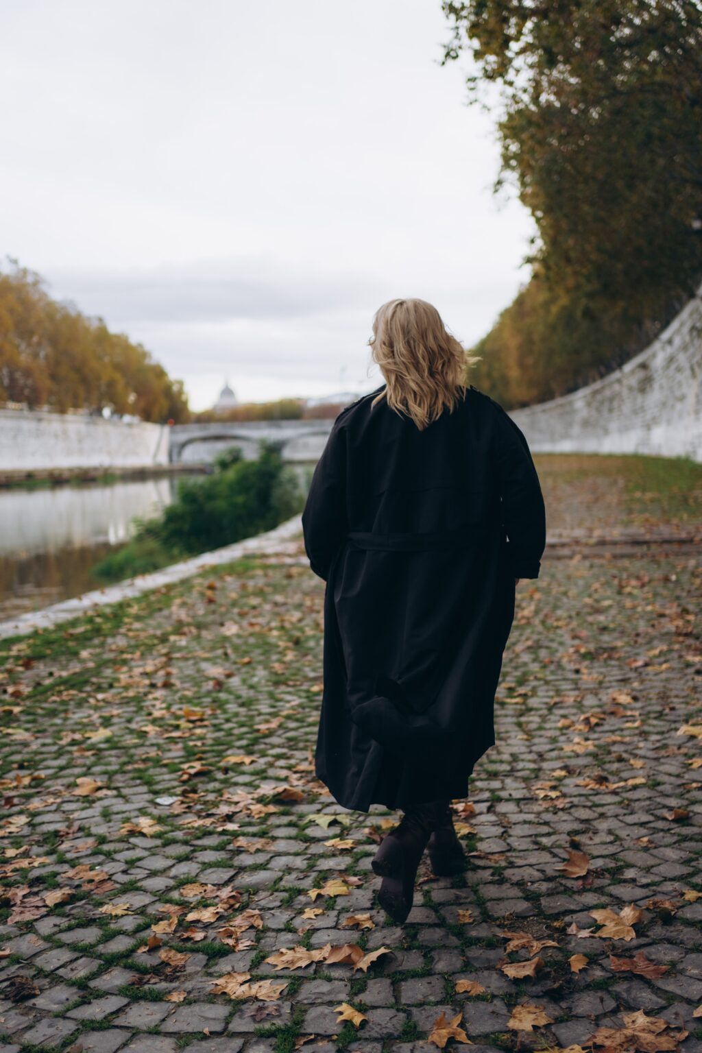 Walking along the Tiber embankment over autumn leaves
