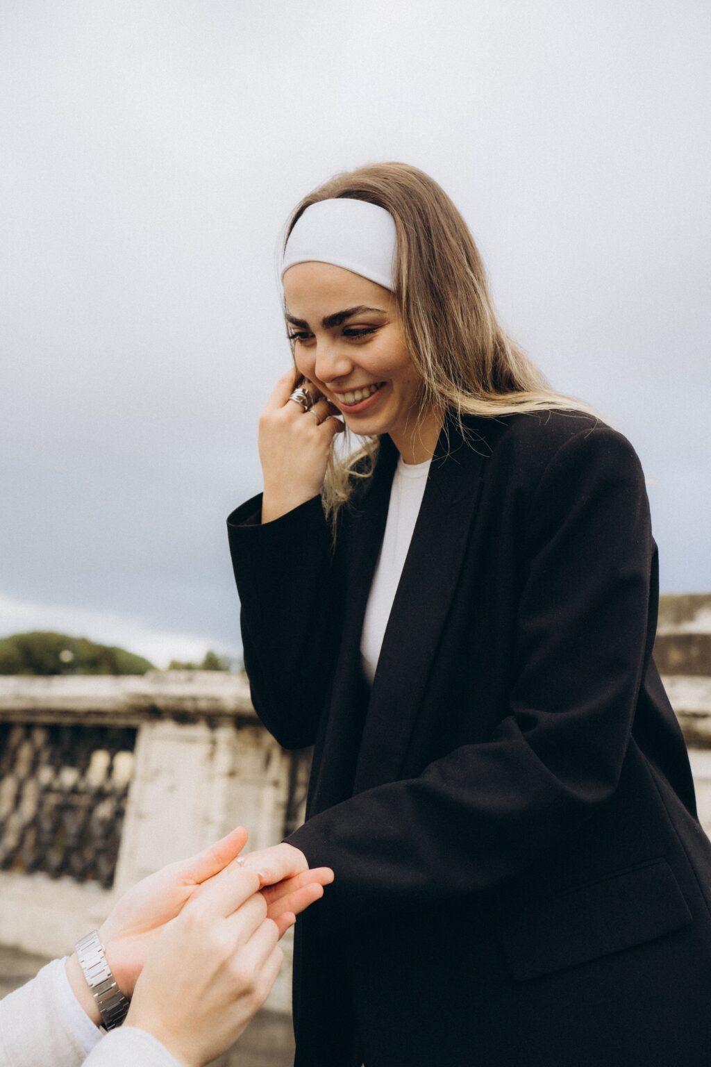 She laughs as he kneels on Ponte Sant'Angelo