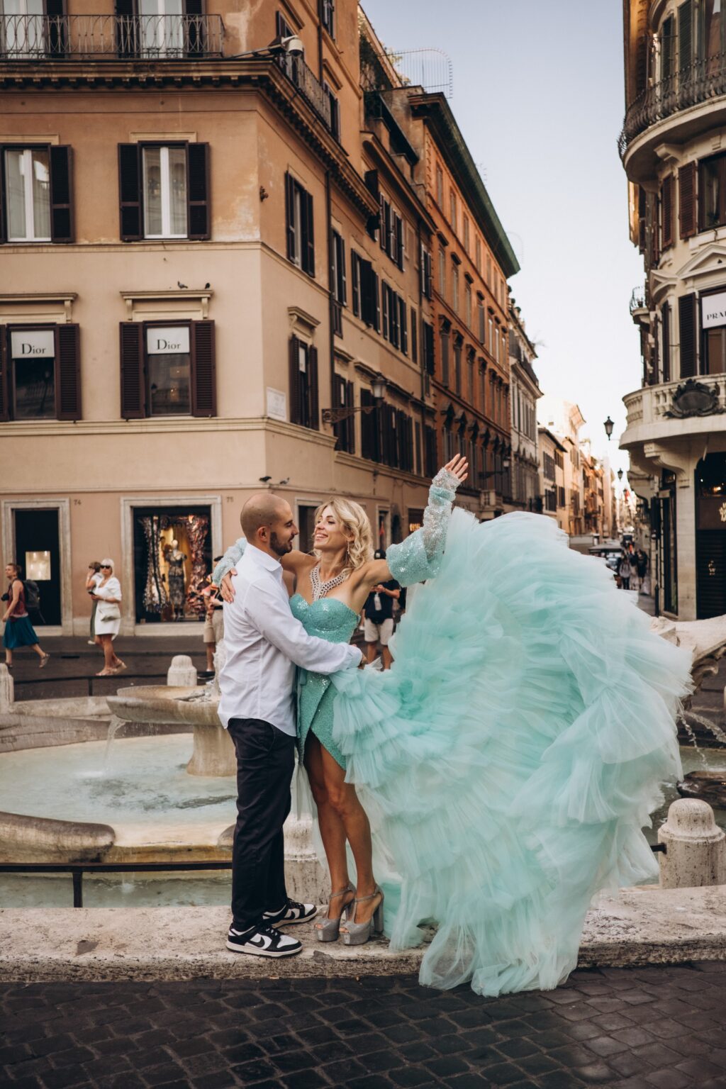 Couple by the Barcaccia fountain in Piazza di Spagna at the foot of the Spanish Steps