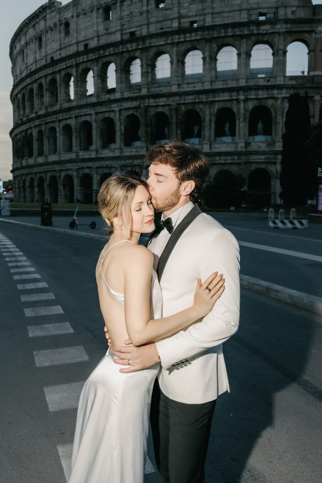Bride and groom embracing in front of the Colosseum