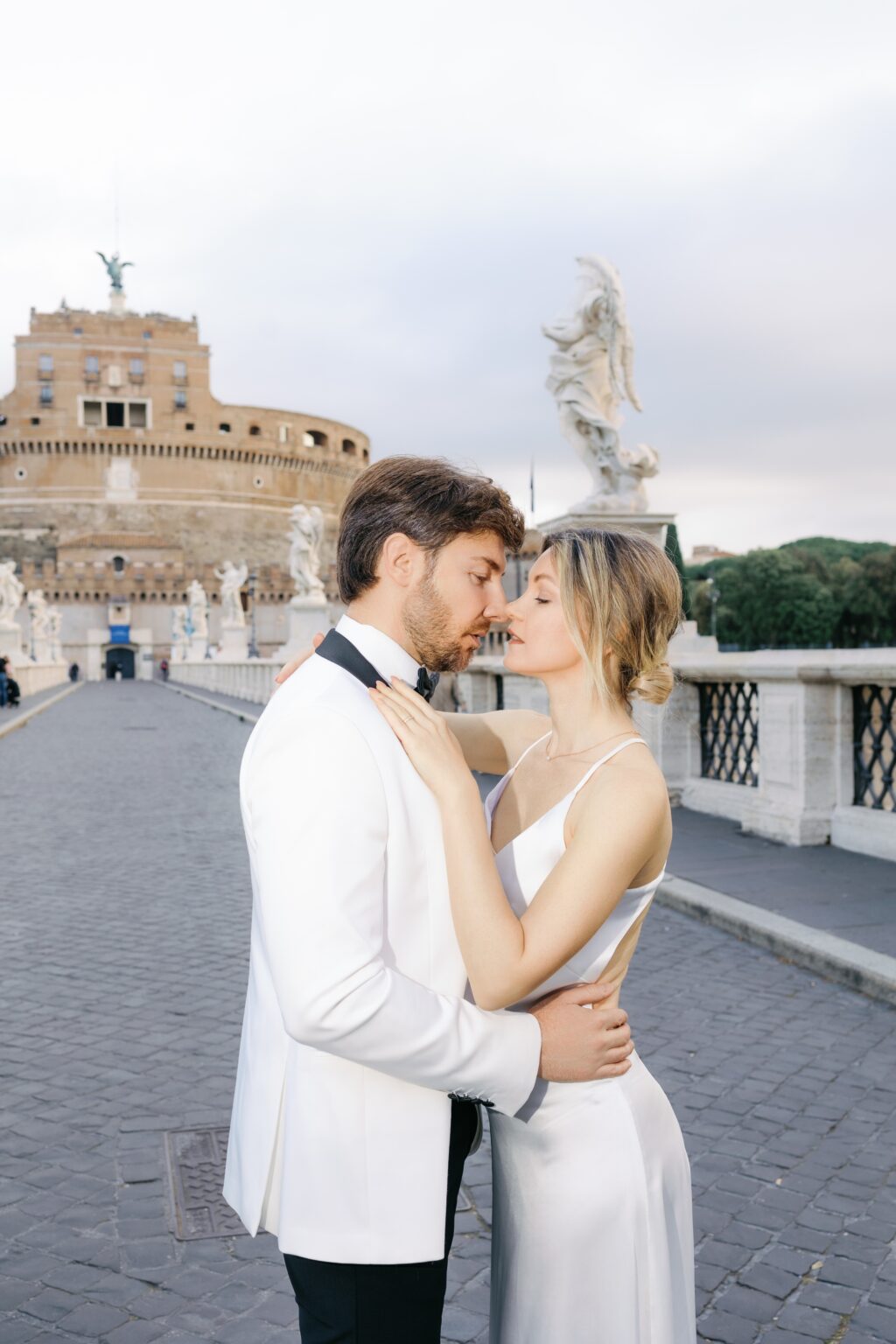 Bride and groom on Ponte Sant'Angelo with Castel Sant'Angelo behind